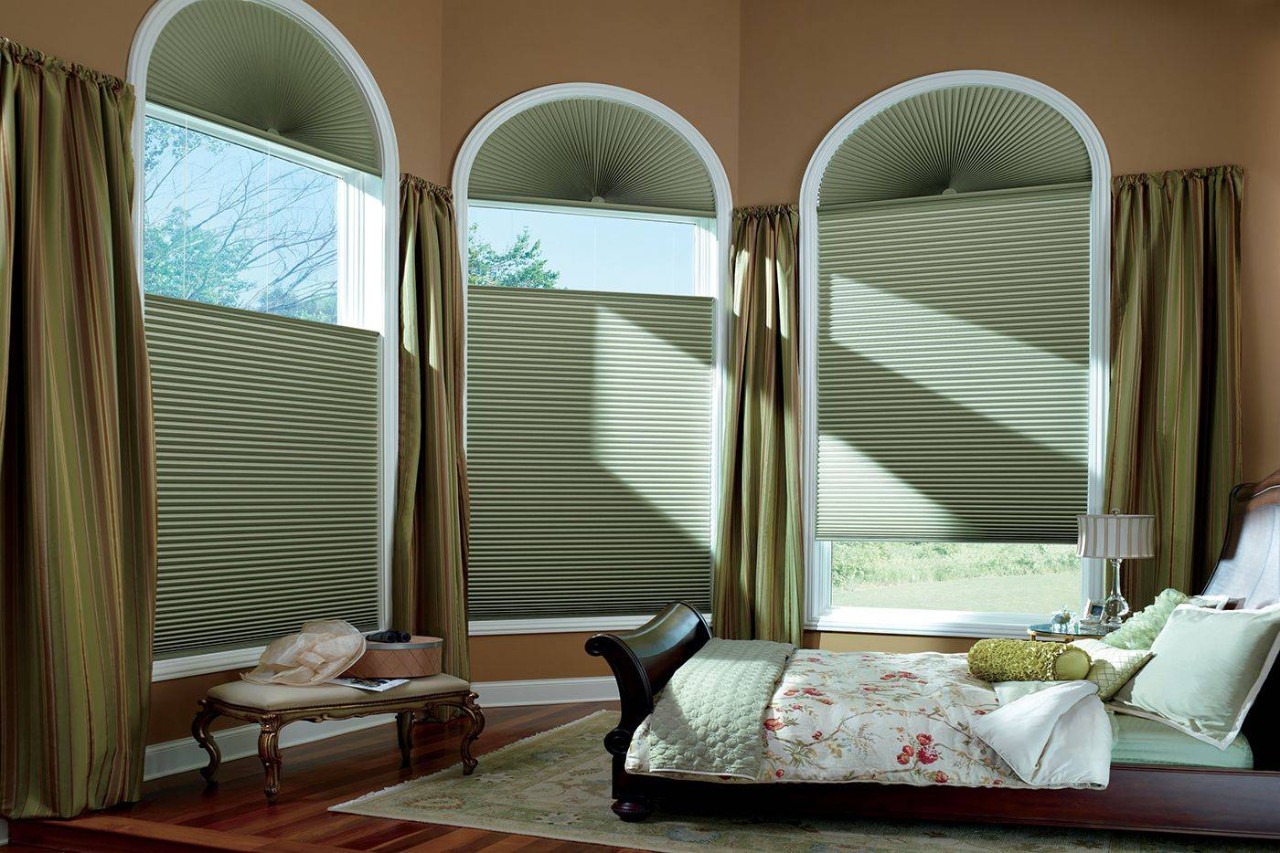 Bedroom with three large arched windows covered by green Hunter Douglas Duette® Cellular Shades at Designing Windows near Ocean City, Maryland