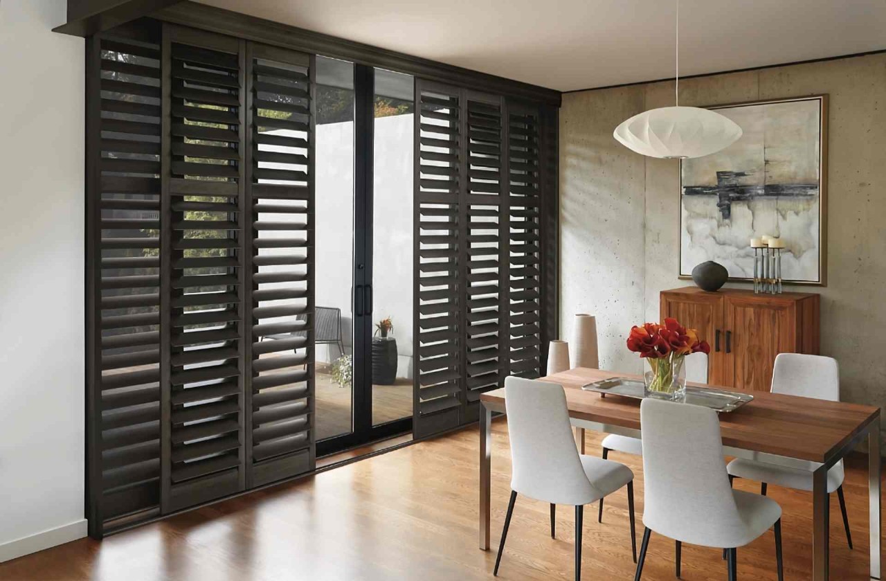 Dark Hunter Douglas NewStyle® Composite Shutters custom fit for a dining room's sliding door near Ocean City, MD